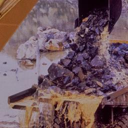 Excavator dumping rocks int...